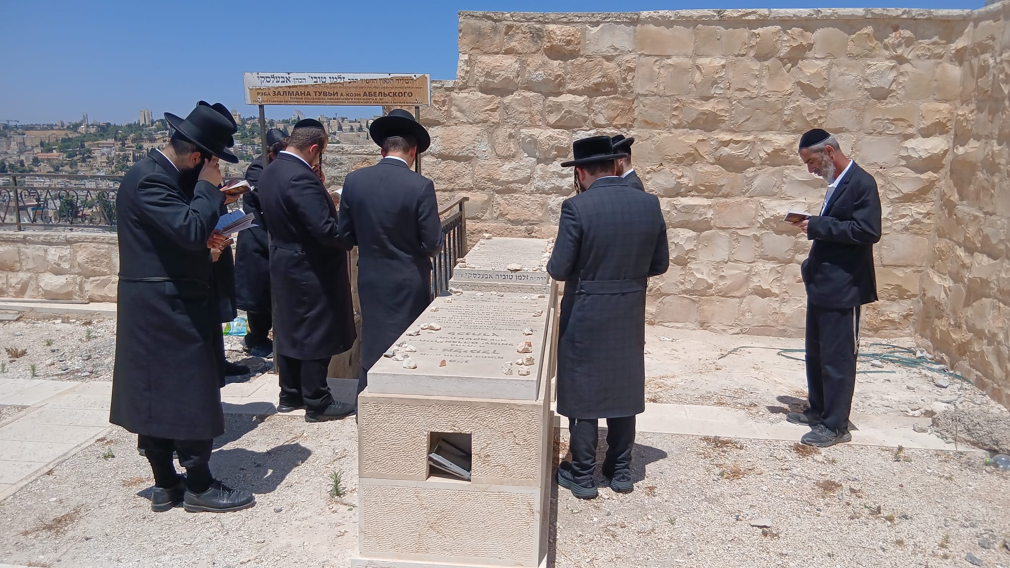 Minyan of yeshiva students praying at grave on Har HaZeitim Jerusalem